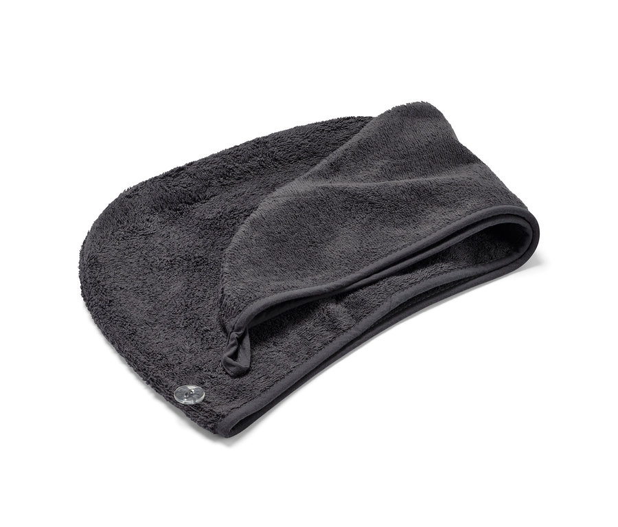Une serviette turban anthracite est posée pliée sur un fond blanc.