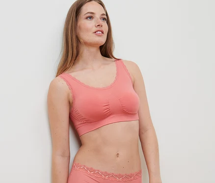Une femme porte une brassière sans coutures abricot.