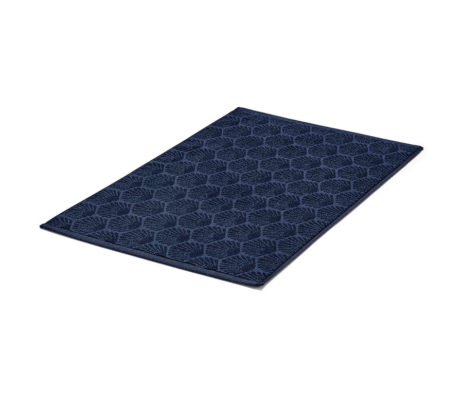 Tapis de douche bleu marine « Coquillage » sur fond blanc.