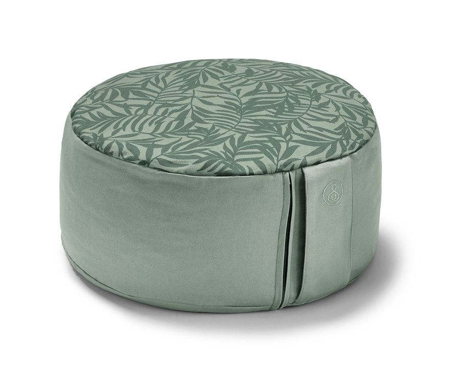 Coussin de méditation vert avec un imprimé de feuilles.