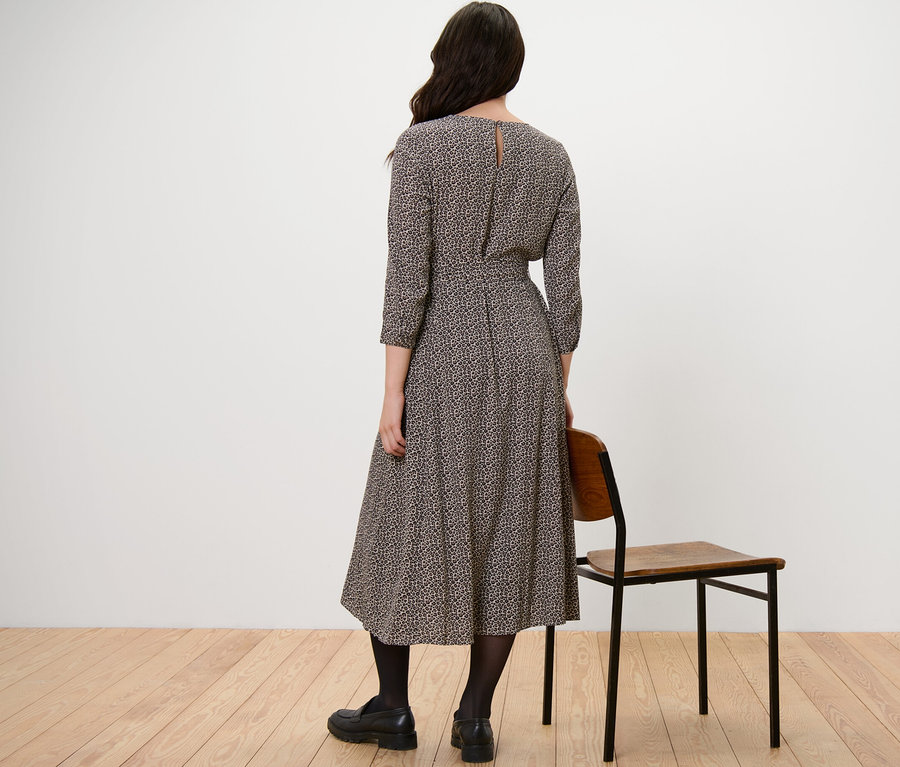 Une femme, vue de dos, porte une robe tissée imprimée.