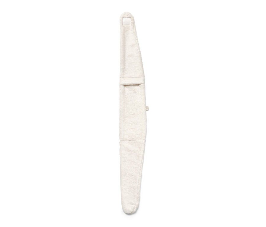 Une bouillotte blanche avec un ruban repose sur un fond blanc.