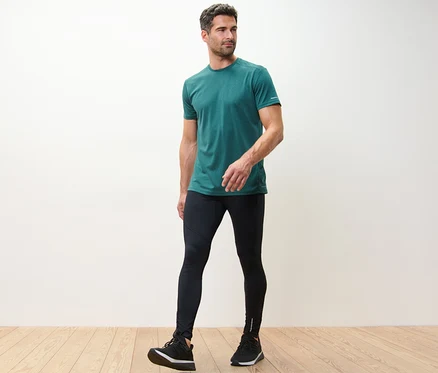 Homme portant un t-shirt vert et un legging de sport noir.
