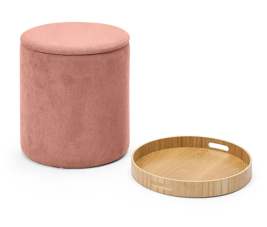 Un pouf en tissu rose à côté d'un plateau rond en bois sur fond blanc.