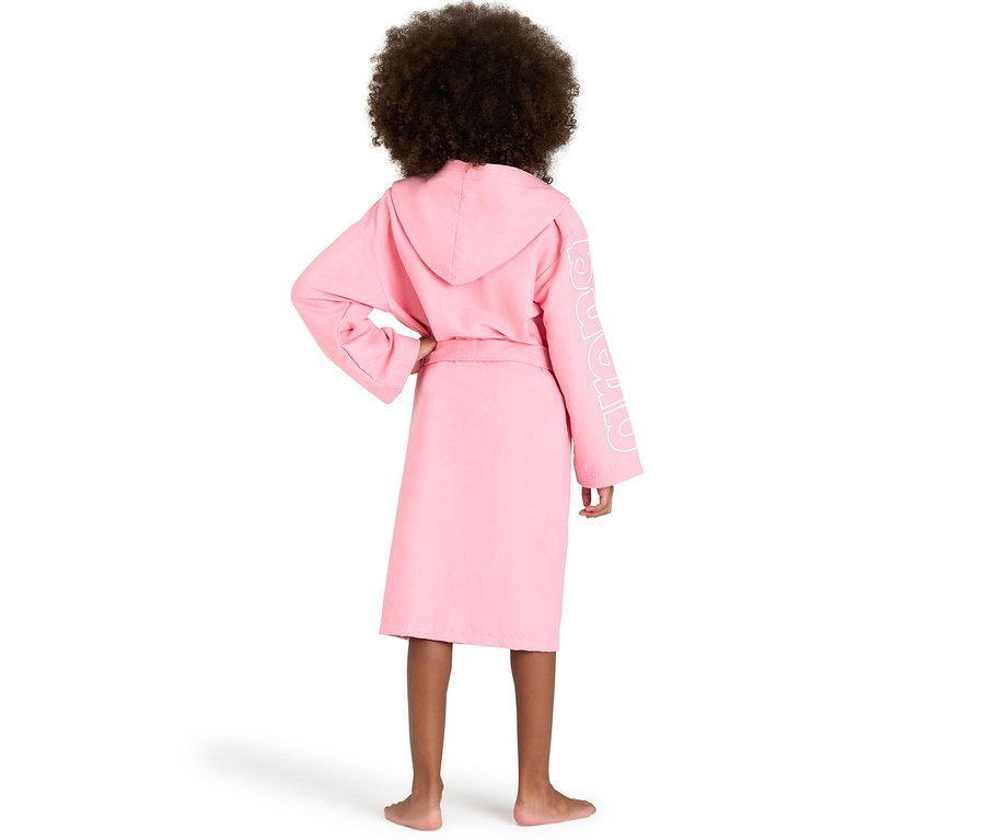 Enfant de dos portant un peignoir pour enfant arena Zeal Plus JR rose à capuche avec le logo blanc sur la manche.