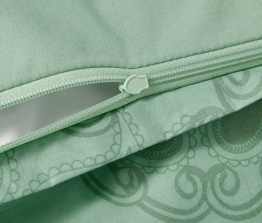 Détail de la parure de lit en renforcé verte avec un mandala et une fermeture éclair.