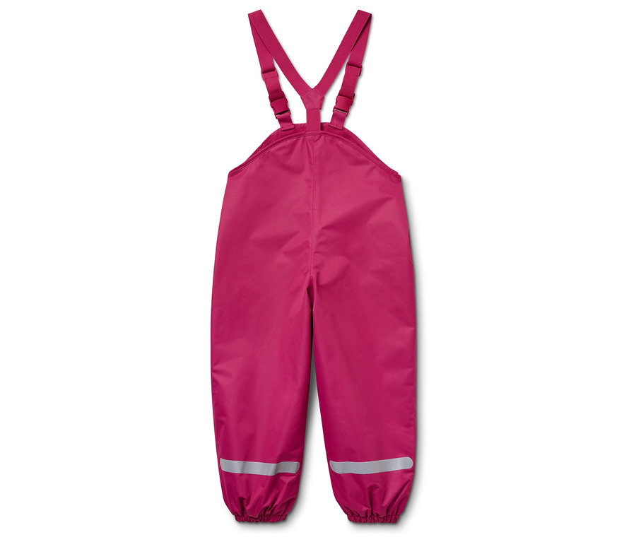Un pantalon de pluie rose pour enfant avec des bretelles et des bandes réfléchissantes sur les jambes, allongé sur un fond blanc.