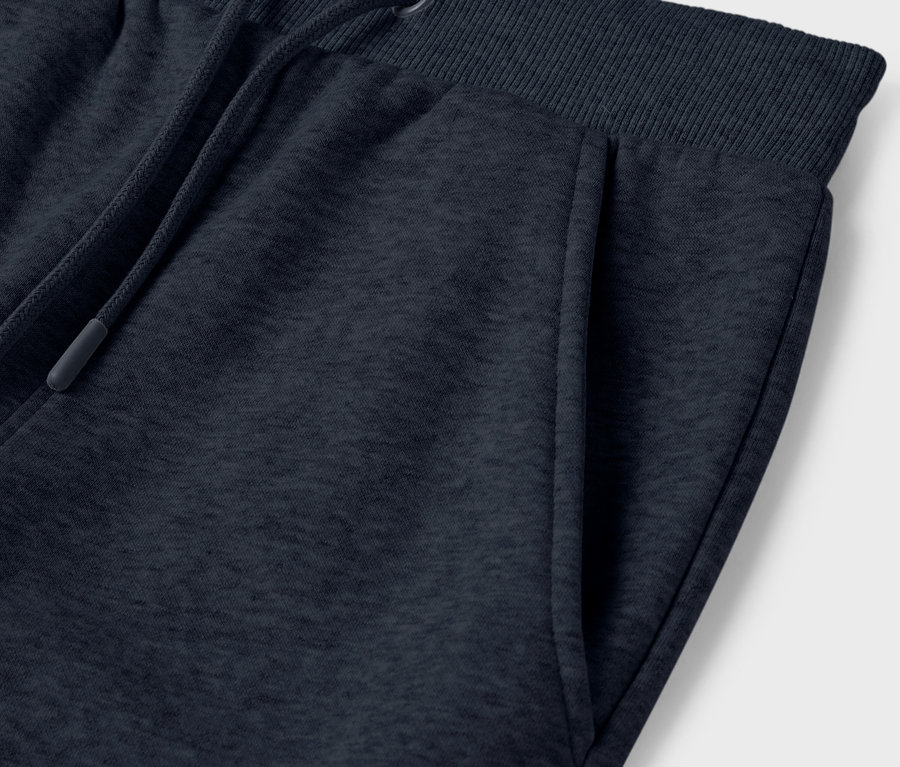 Gros plan sur un pantalon de jogging bleu marine avec une poche et un cordon de serrage à la taille.