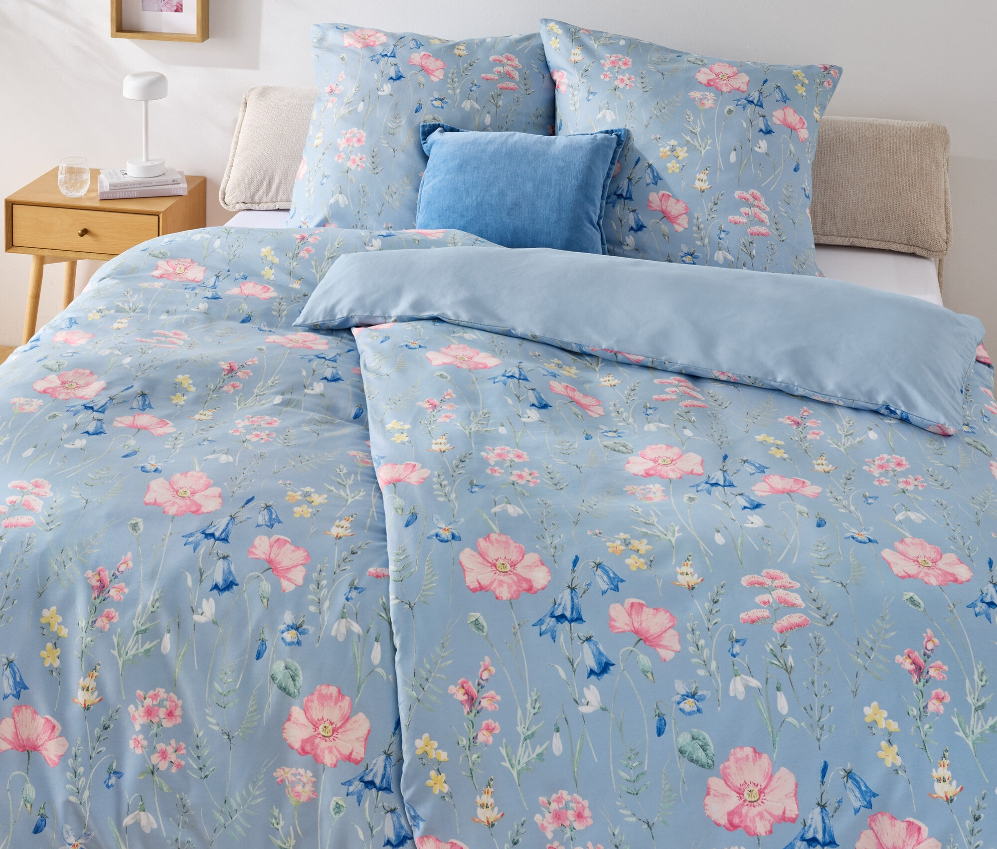 Lit bleu avec literie en microfibre à motif floral, taille standard et literie en microfibre, taille surdimensionnée.