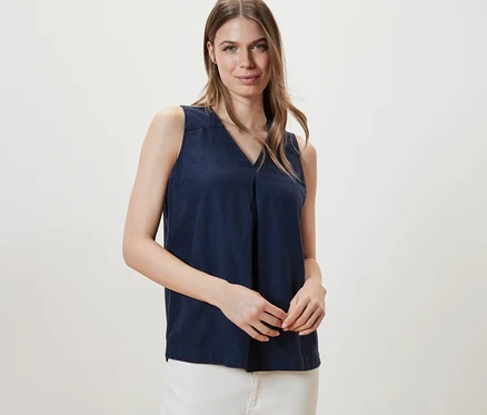 Femme posant en chemisier sans manches en lin, bleu marine.