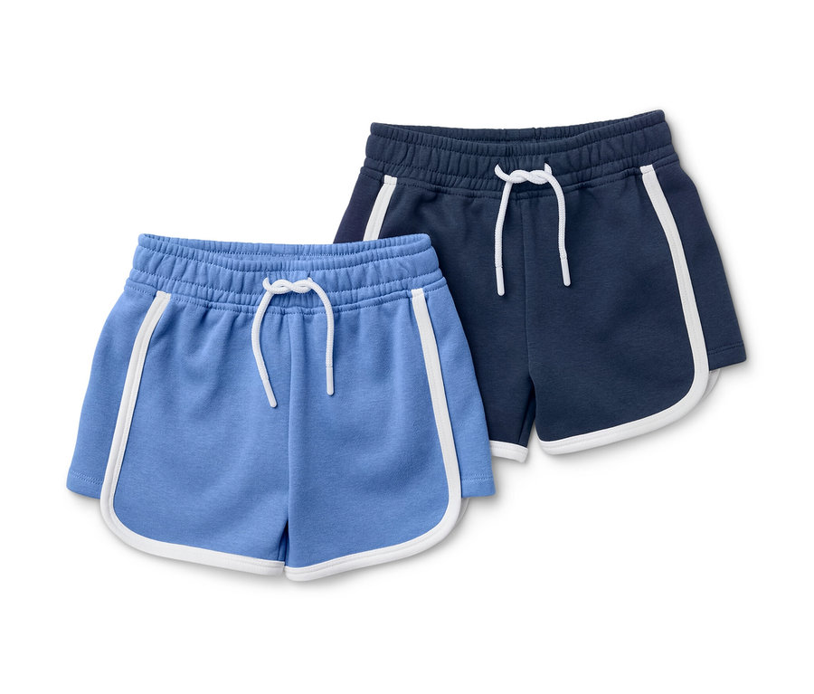 Deux shorts en sweat pour enfant, un bleu clair et un bleu marine, chacun avec un passepoil blanc.