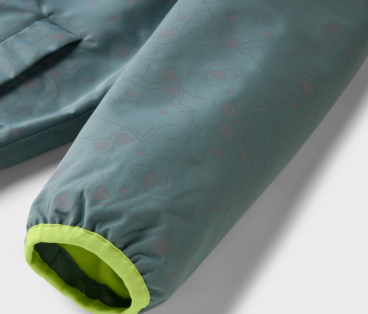 Détail d'une veste de pluie thermique pour enfant avec éléments réfléchissants.