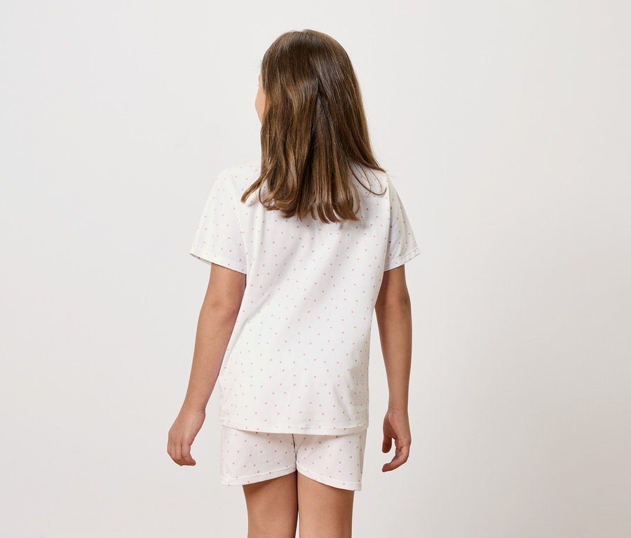 Une fille en pyjama à manches courtes et short, vue de dos.