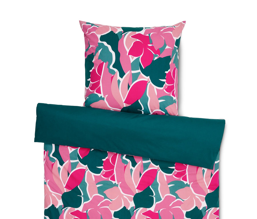 Une parure de lit en percale composée d'un oreiller à motif floral et d'une couette à bordure vert foncé.