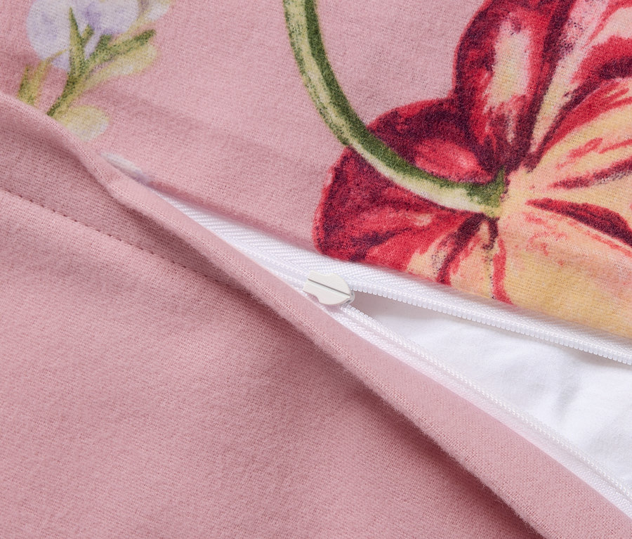 Gros plan d'une parure de lit en molleton rose de grande taille avec un motif floral et une fermeture éclair.