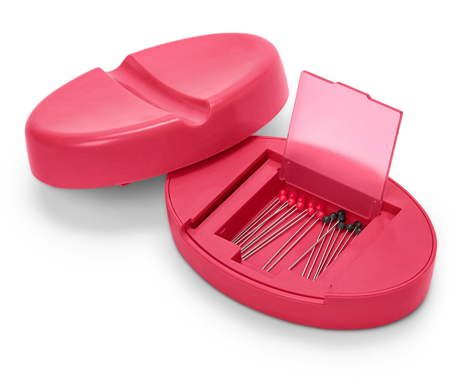 Boîte à aiguilles magnétique rose ouverte avec des aiguilles à l'intérieur.