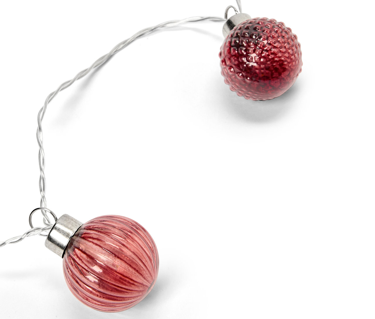 Deux boules décoratives rouges sur un fil d'argent sur fond blanc.