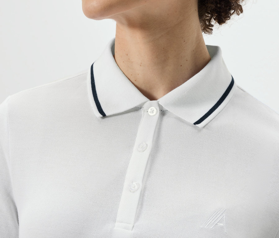 Haut du corps d'une personne portant un polo technique blanc.