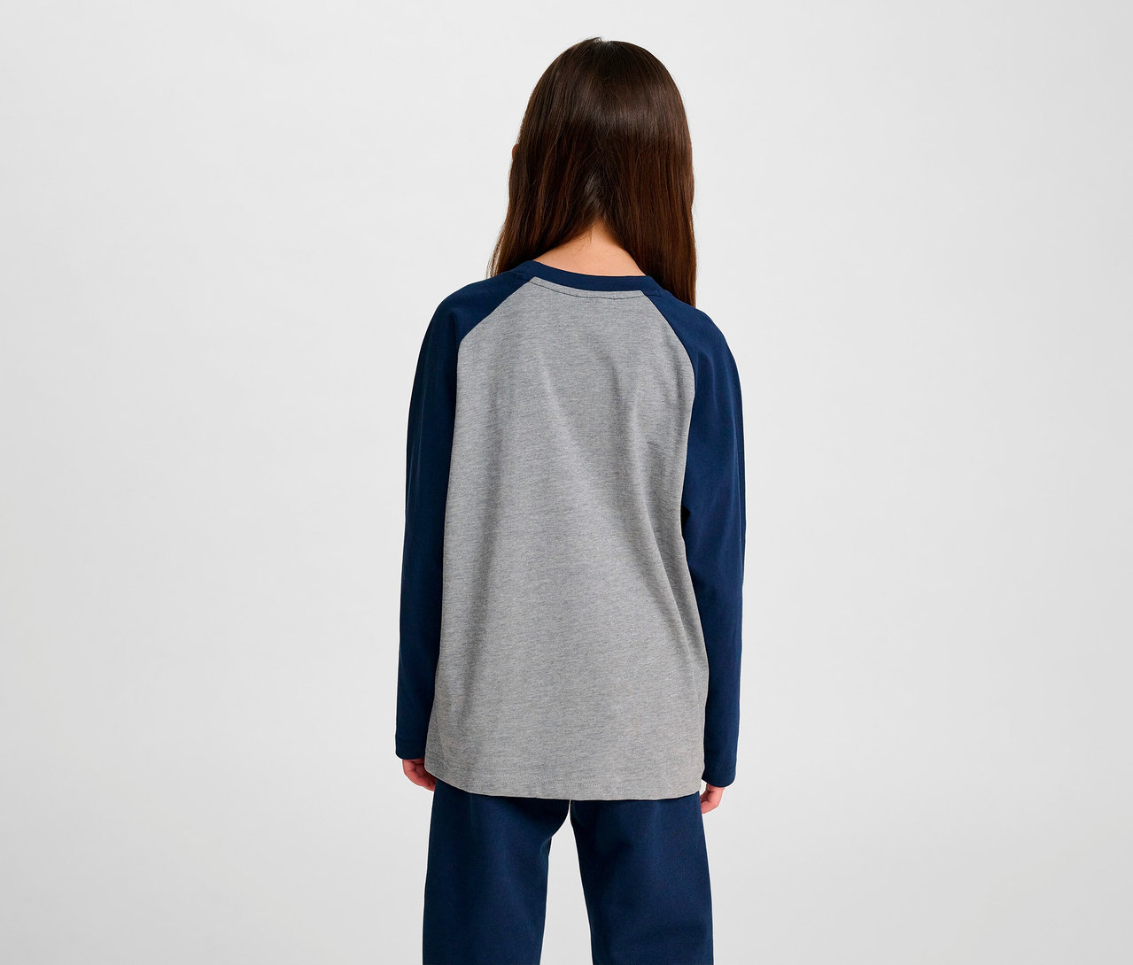 Vue arrière d'une fille portant un t-shirt ample à manches raglan HUMMEL HMLJR BEE bleu.