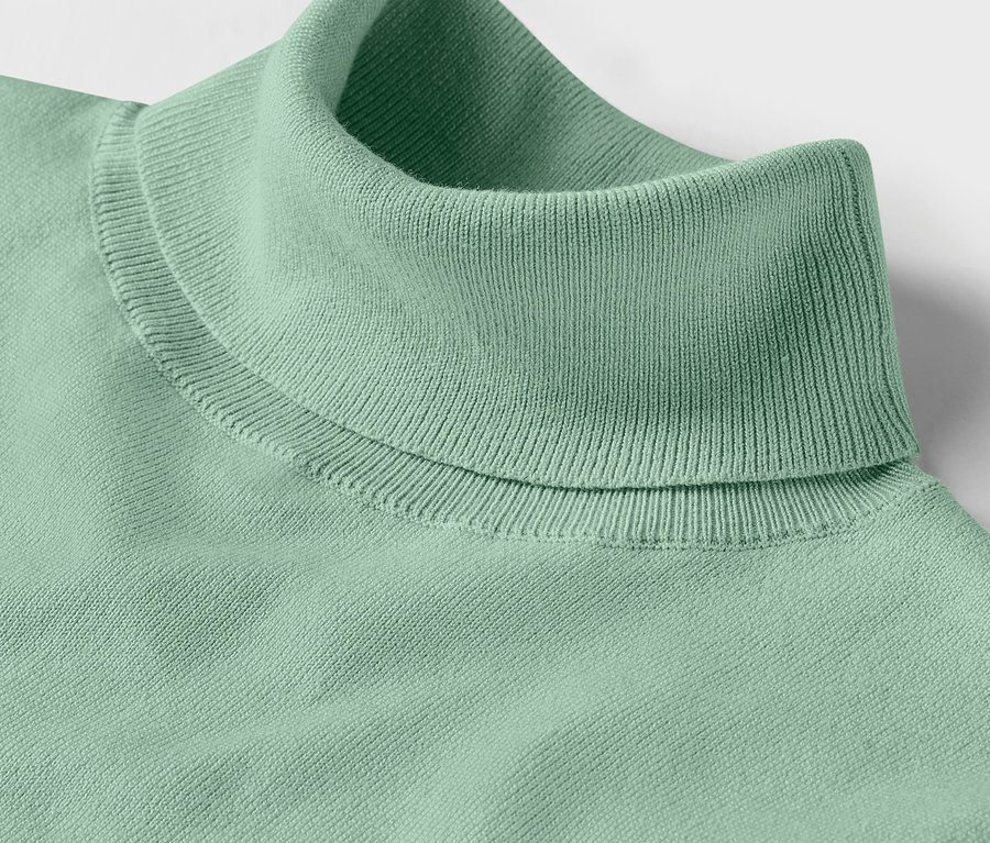 Gros plan d'un pull à col roulé en maille fine de couleur menthe.