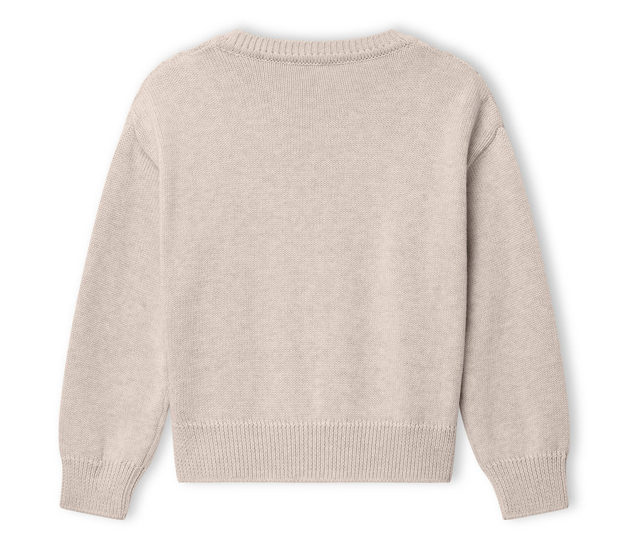 Un pull beige est posé sur un fond blanc.