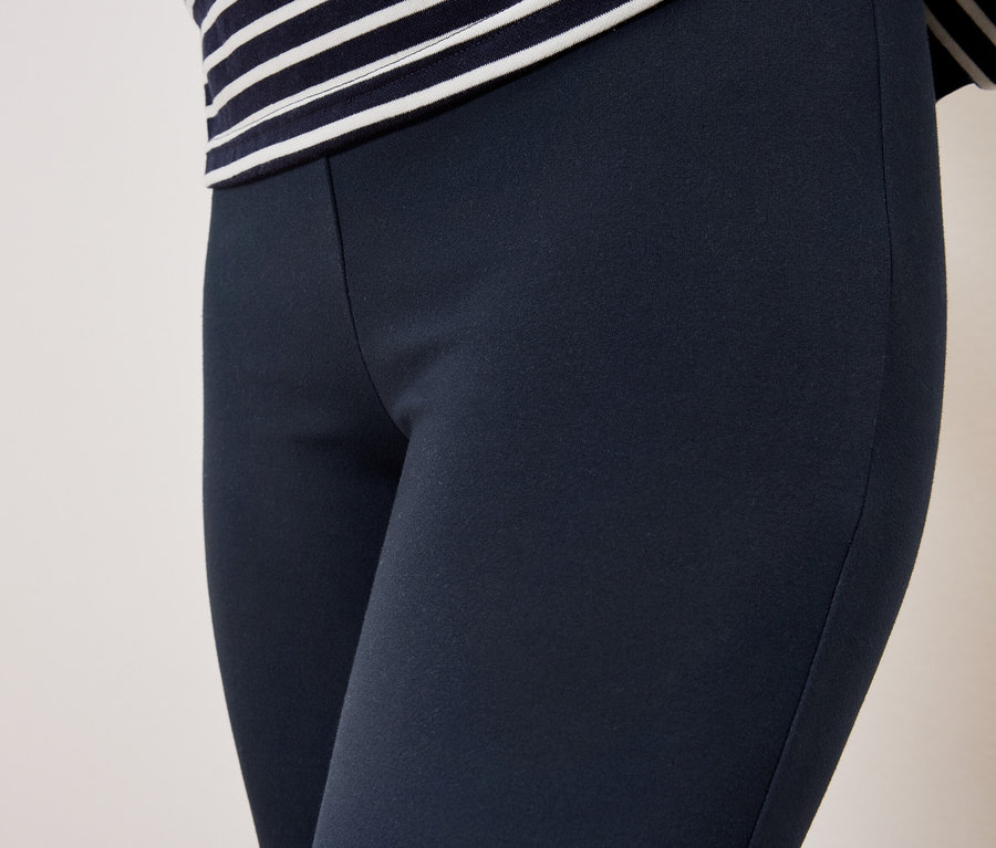 Gros plan sur des leggings bleu marine pour femmes avec un haut rayé.