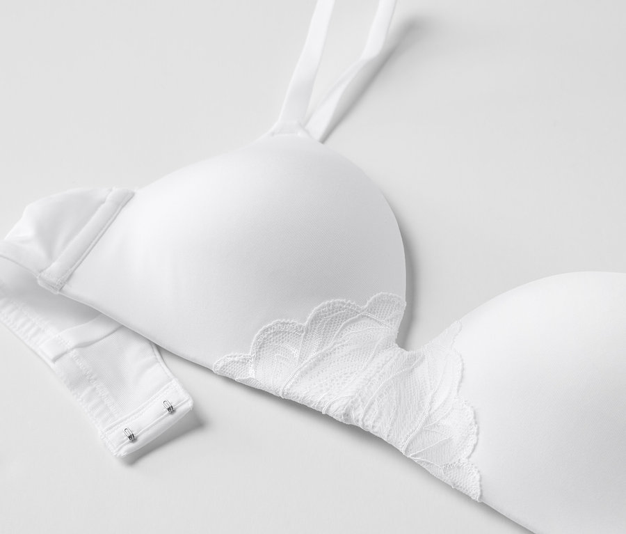 Vue détaillée d'un soutien-gorge blanc à coques souples avec de la dentelle sur fond blanc.