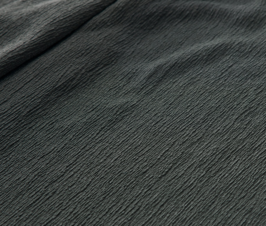 Gros plan d'un pantalon à enfiler vert avec un effet crinkle.