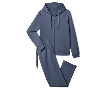 Sur un fond blanc, un survêtement bleu comprenant un sweat à capuche et un pantalon de jogging.