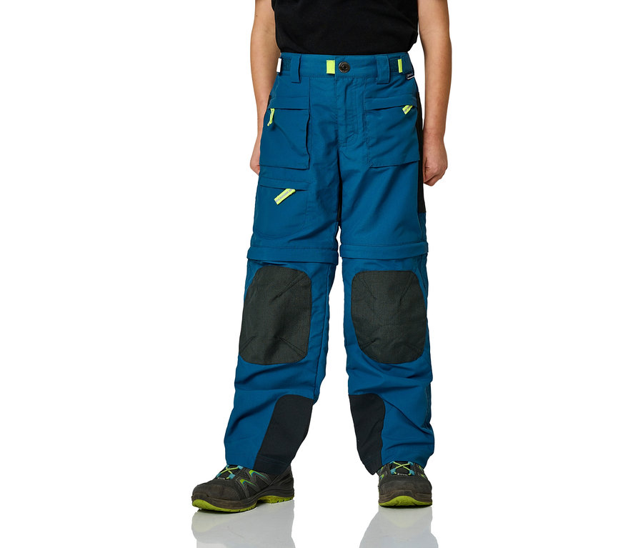 Un enfant porte un pantalon d'extérieur bleu avec des poches et des genouillères, associé à des chaussures de randonnée.