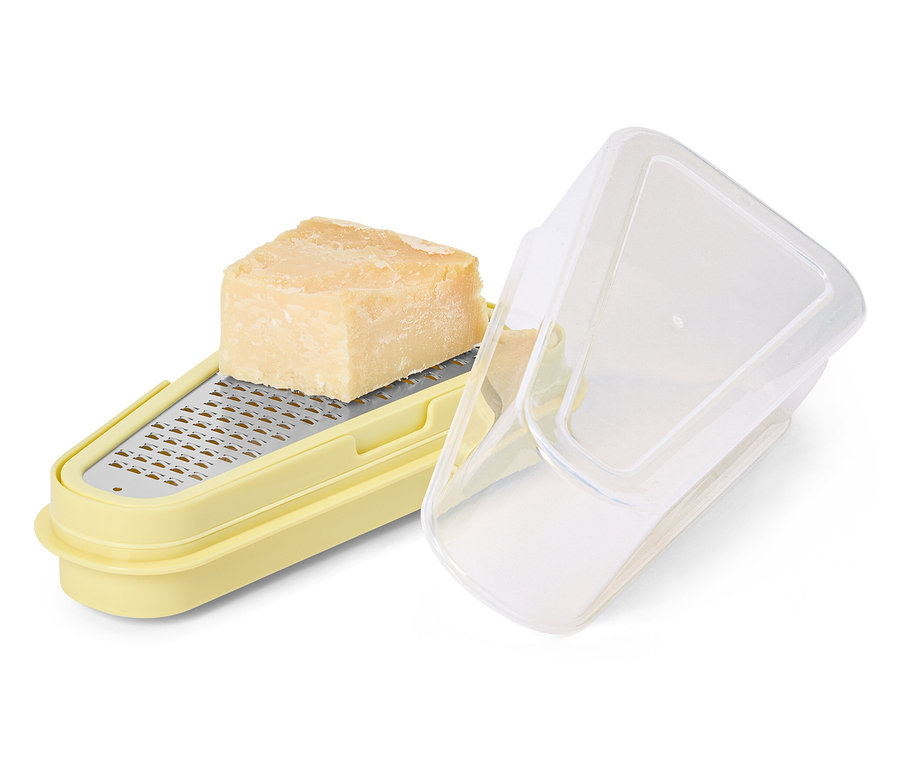 Parmesan sur une râpe à parmesan jaune avec récipient.