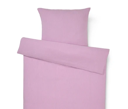 Gros plan d'une parure de lit violette avec une taie d'oreiller.