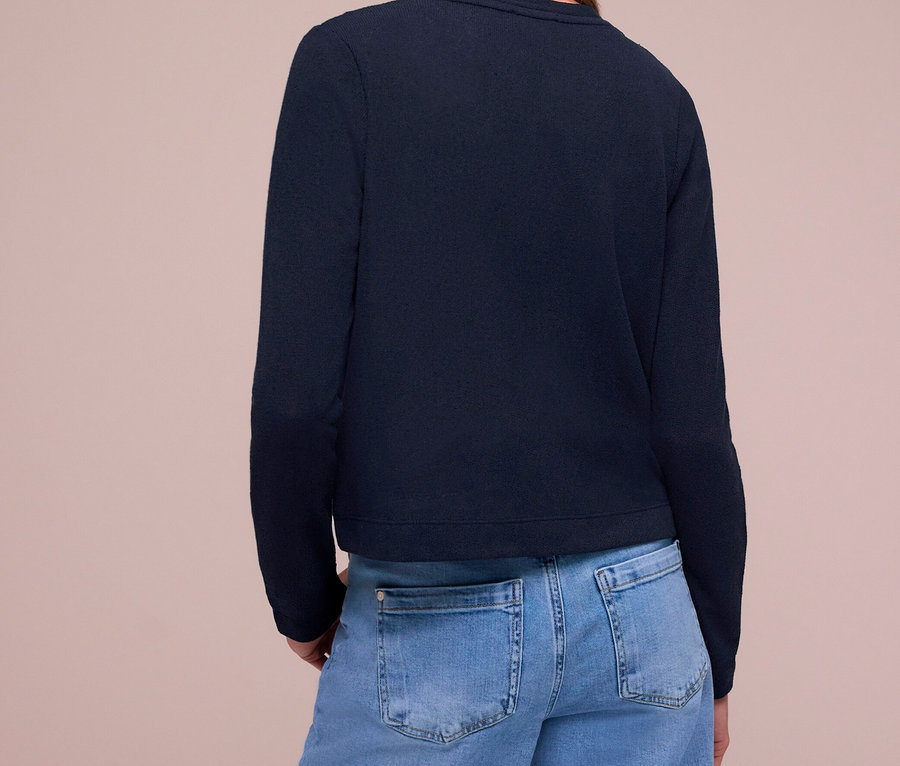 Femme de dos, portant un Cardigan Street One bleu marine et un jean bleu clair.