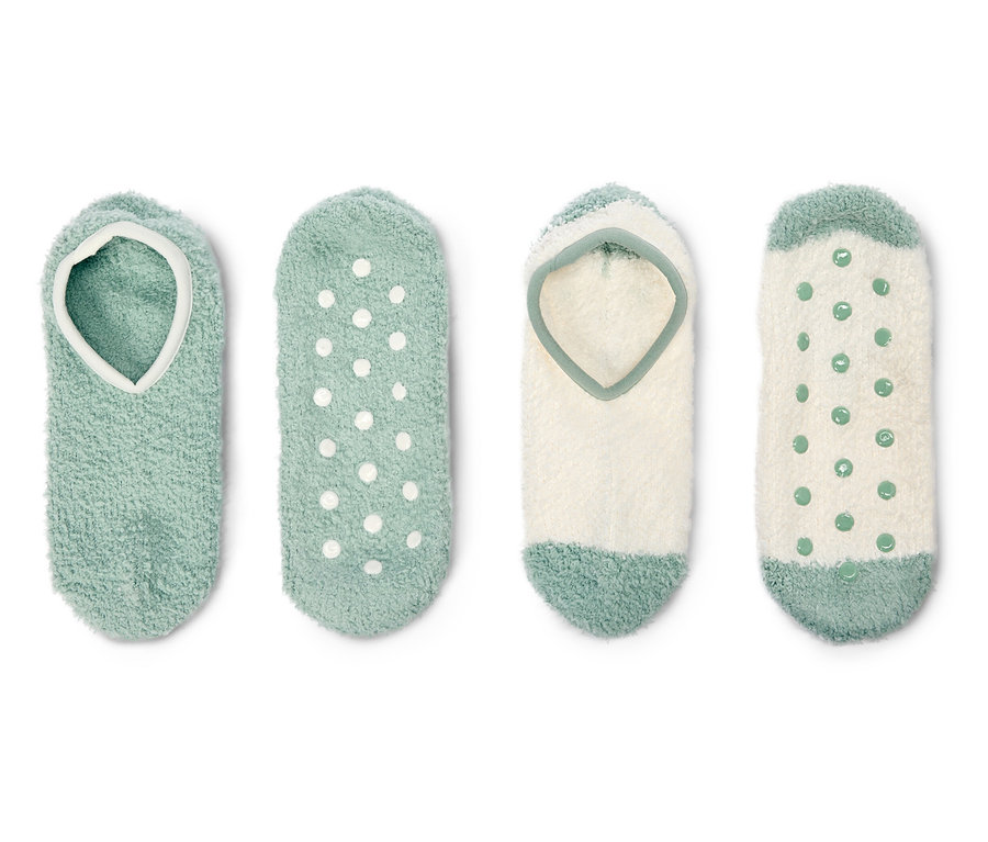 Quatre paires de chaussettes duveteuses vertes et blanches sont posées sur un fond blanc.