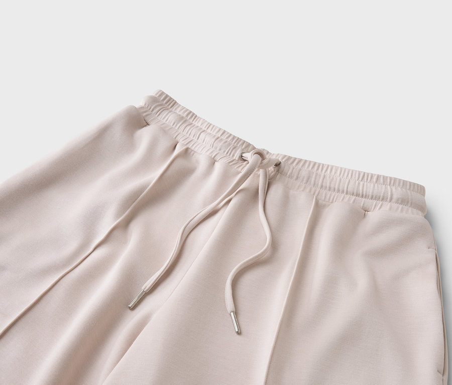 Gros plan d'un pantalon beige avec cordon de serrage.