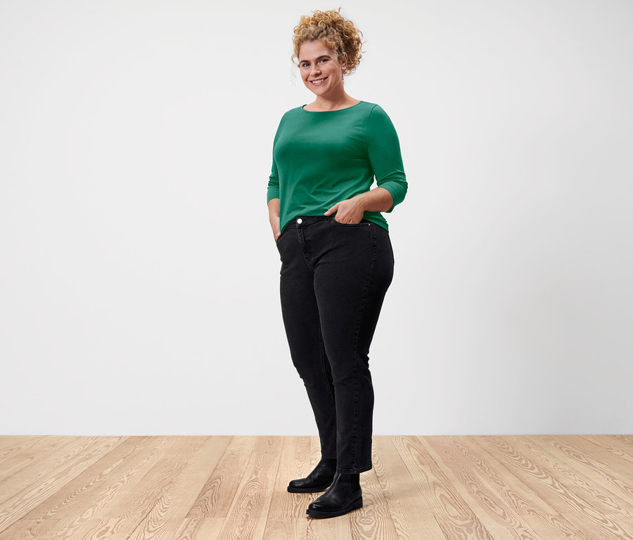 Femme posant dans un t-shirt vert à manches 3/4.