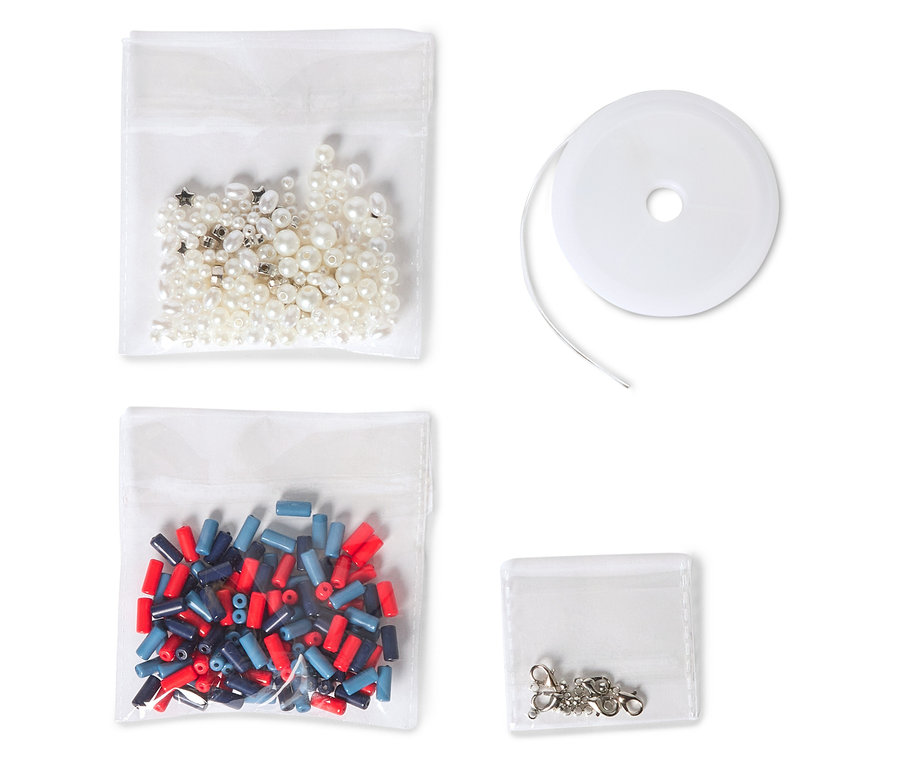 Sur fond blanc, quatre sachets transparents contenant des perles, des fermoirs pour bijoux et du fil pour bijoux.