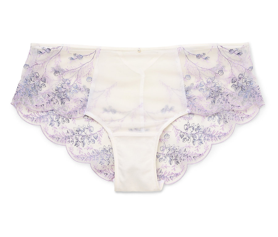 Une paire de culottes blanches pour femmes avec des broderies florales bleues reposent sur un fond blanc.