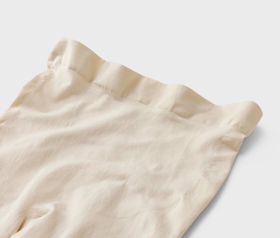 Gros plan sur un legging beige à taille haute sur fond blanc.
