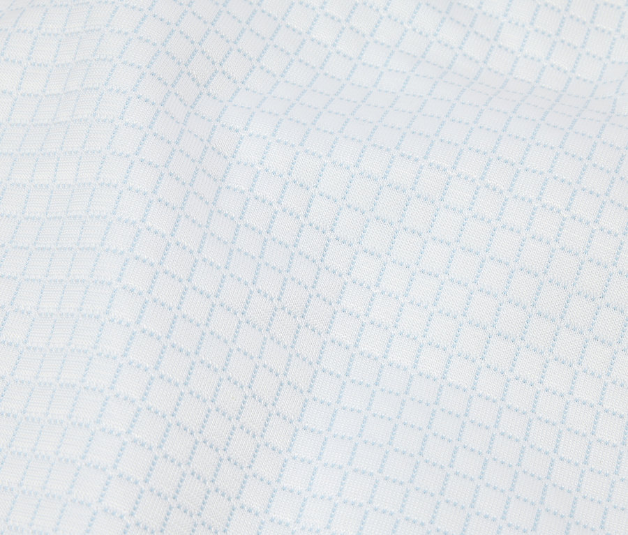 Gros plan d'un tissu blanc avec un motif losanges bleu clair.