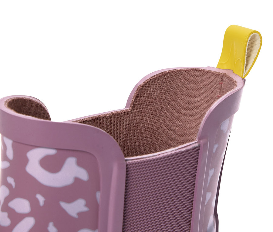 Gros plan sur une bottine Chelsea rose à motif léopard avec une languette jaune.
