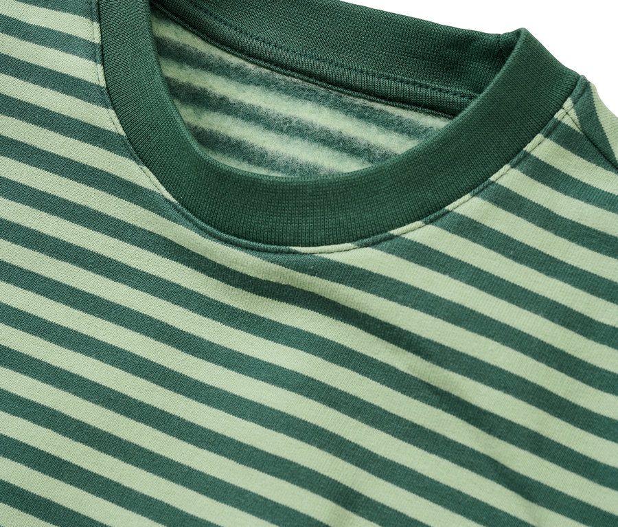 Gros plan d'un sweat-shirt rayé vert et vert clair avec un col rond côtelé vert foncé. L'intérieur du sweat-shirt présente une texture douce semblable à du molleton.