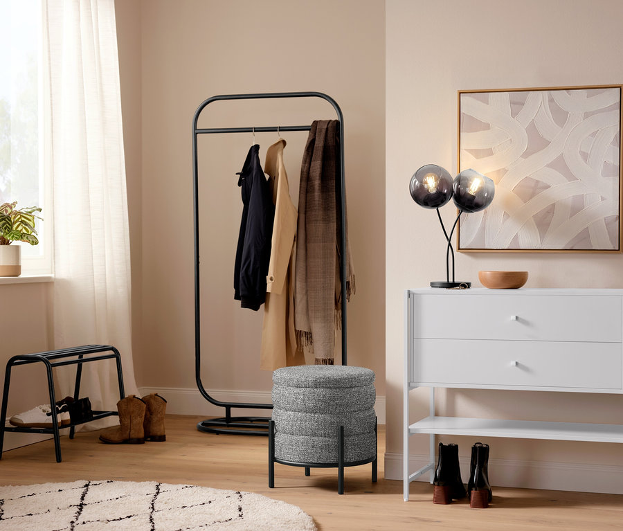 Entrée avec une lampe de table avec abat-jour en verre fumé et un portant.