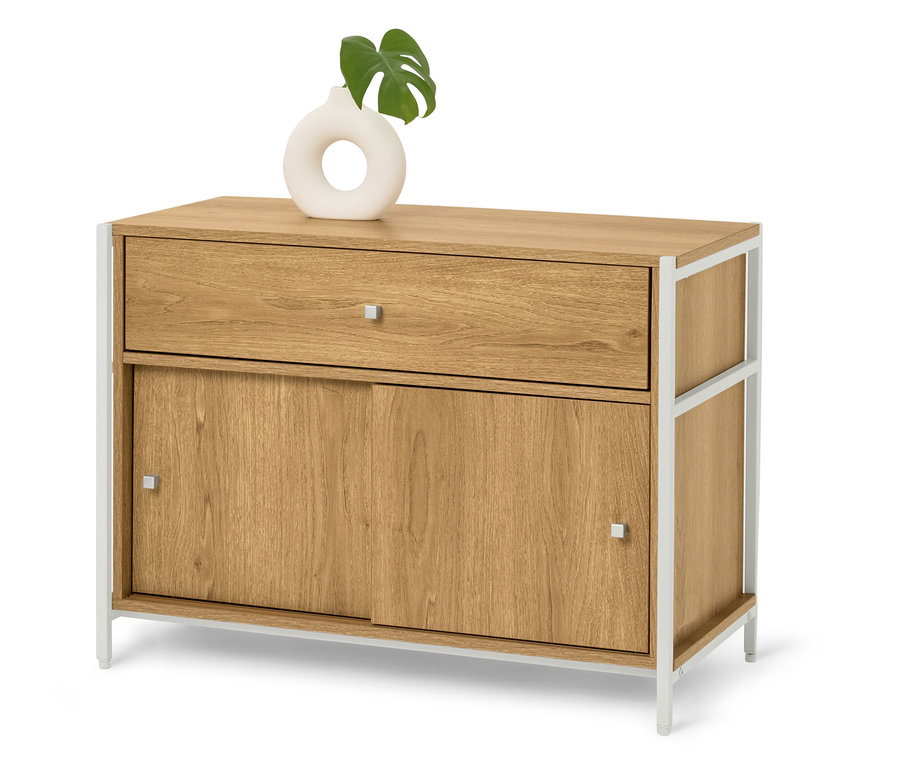 Commode en bois clair avec pieds en métal blanc, sur laquelle repose un vase blanc avec une feuille verte.