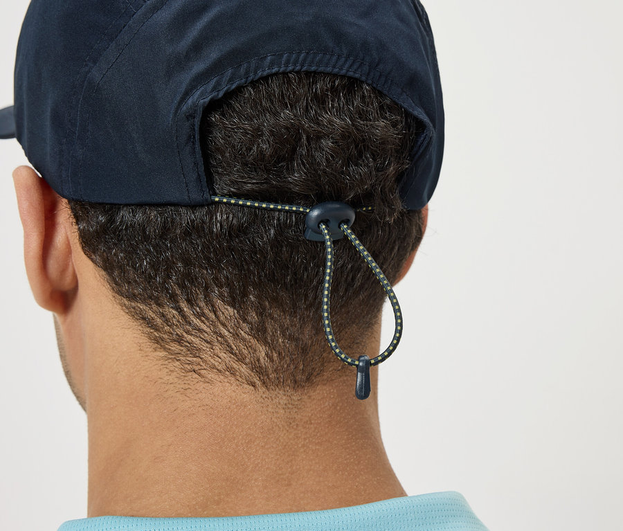 Gros plan sur l'arrière de la tête d'une personne portant une casquette bleu marine avec cordon de serrage réglable.