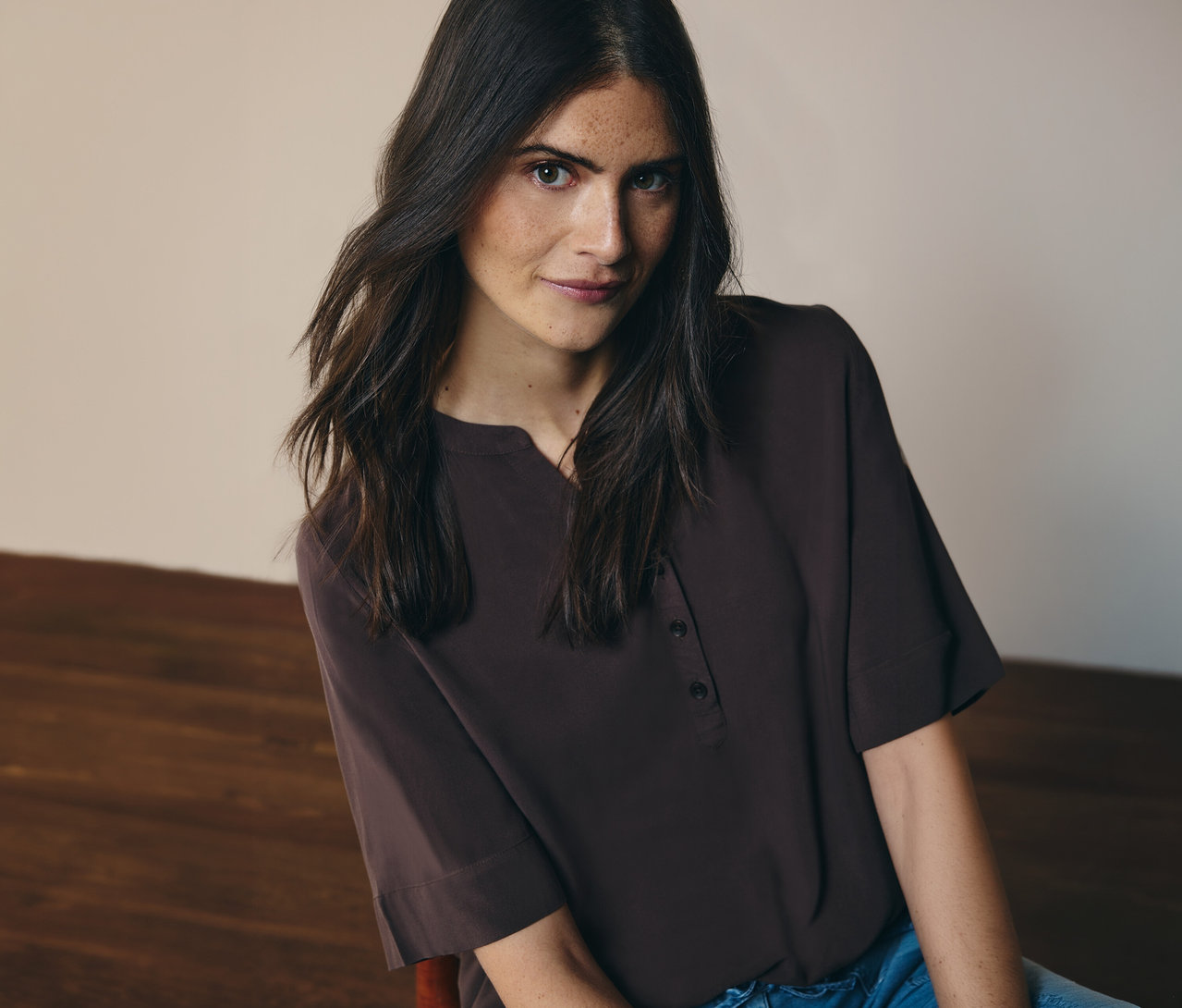 Une femme porte un chemisier tunique marron CECIL avec un jean.