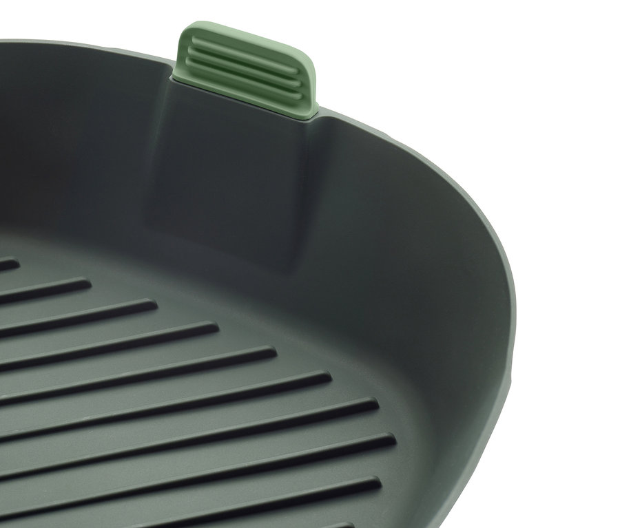 Gros plan d'une poêle à griller carrée grise avec une poignée verte.