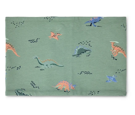 Un cache-cou vert clair avec des motifs de dinosaures et de vagues est posé sur un fond blanc.