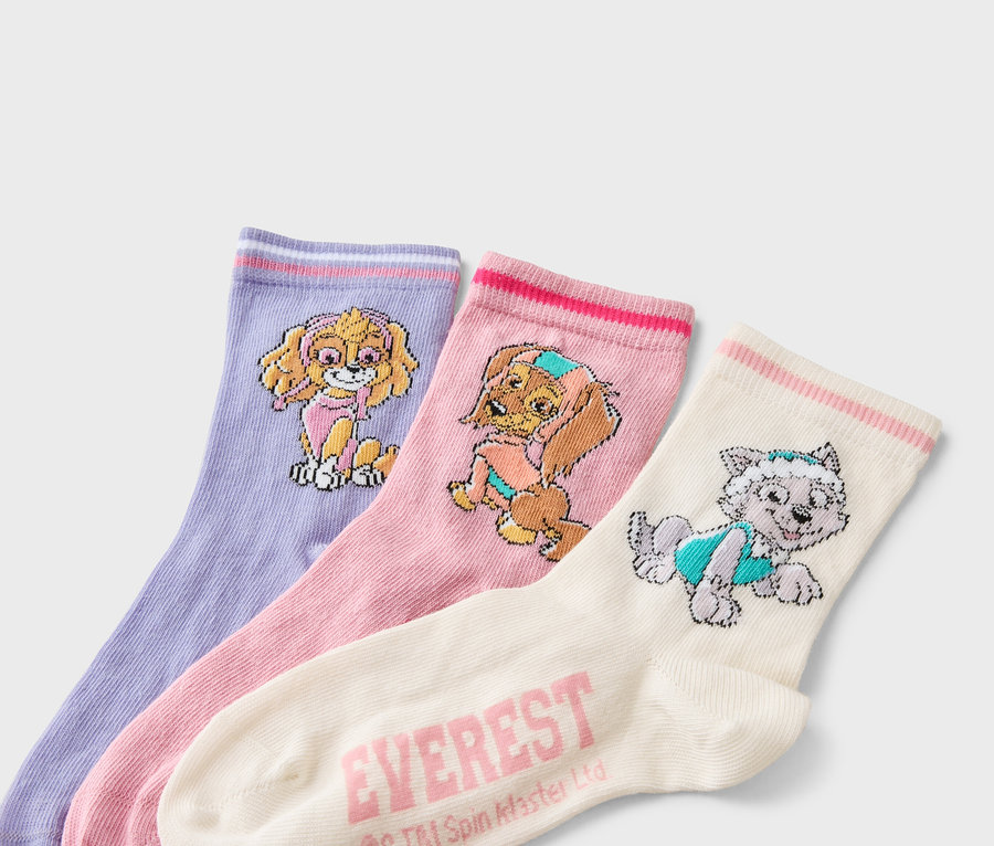 Trois chaussettes côte à côte : une chaussette lavande avec un motif Skye, une chaussette rose avec un motif Everest et une chaussette crème avec un motif Everest.