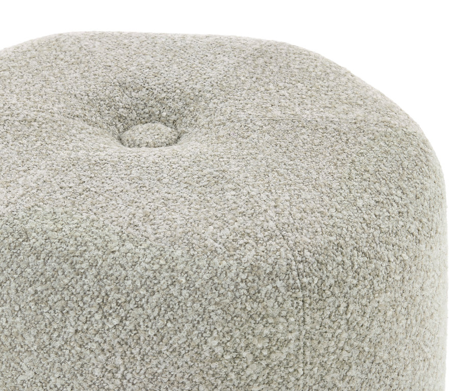 Gros plan d'un tissu texturé gris clair avec un bouton capitonné unique.